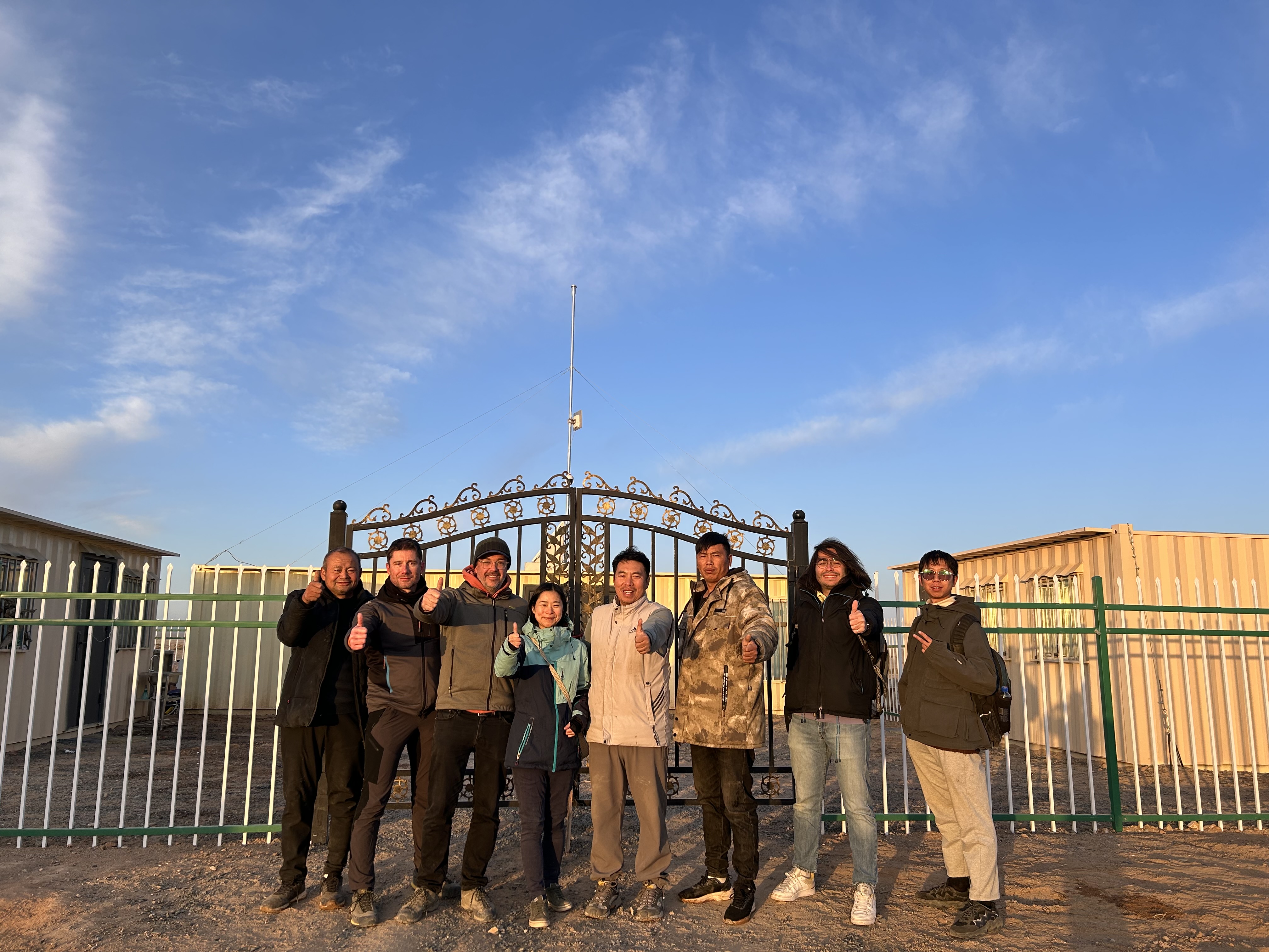 Figure 2 : Une équipe rassemblant des membres de l'Université de Xidian, Purple Mountain Observatory, IAP, LPNHE, et le personnel local, devant la base de vie et d’acquisition de données du prototype Grand, dans le désert de Gobi, Chine.